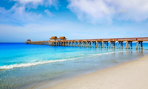 naples florida beach shoreline small waves turquoise water pier