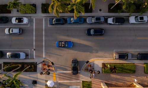 aireal view streetscape cars pedestrians crosswalks palm trees sunset